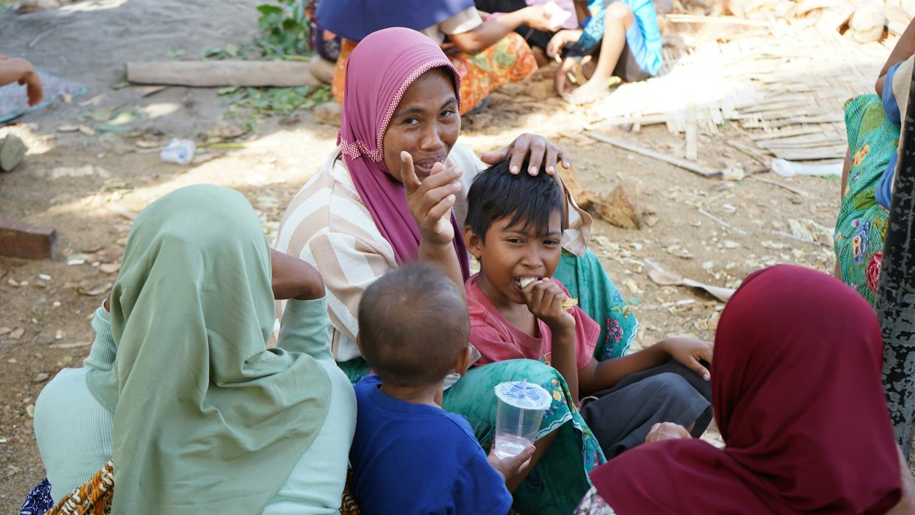 A woman sharing a meal and caring for children in her community